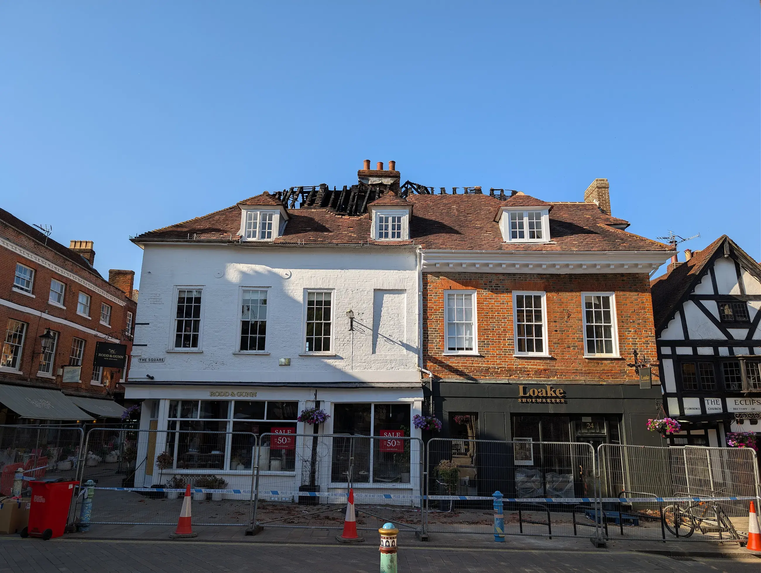 Shop buildings on a town square with a roof burned through by fire