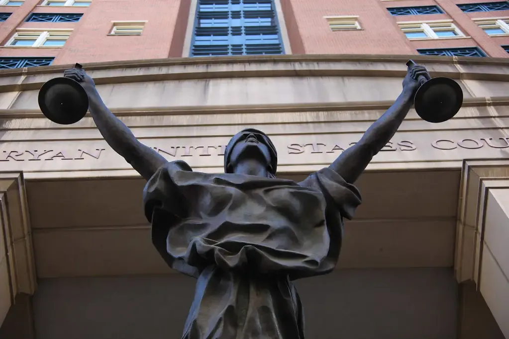 A statue holding scales above the entrance of a federal courthouse