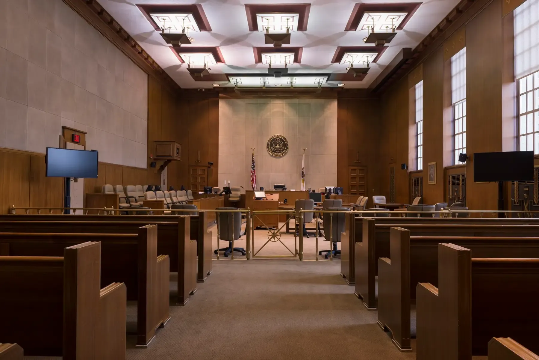 A federal courtroom with the bench, counsel tables and public benches