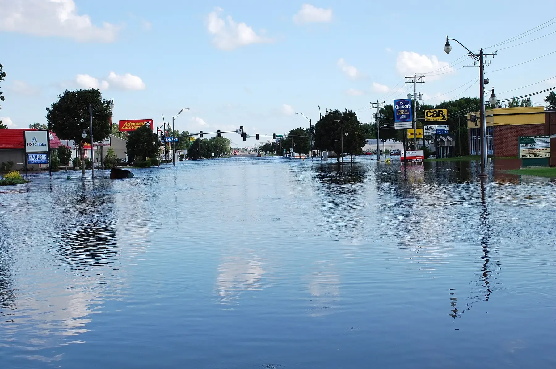 A main street of shops and signs under floodwater